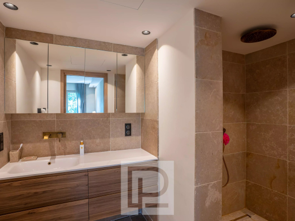 Salle de bain moderne avec douche à l'italienne et meuble en bois, rénovée avec des matériaux naturels.