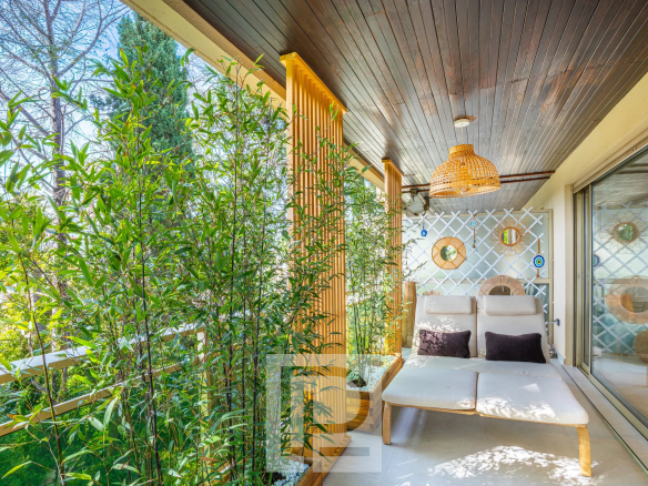 Terrasse d'angle avec mobilier moderne et végétation, appartement rénové à Cannes.