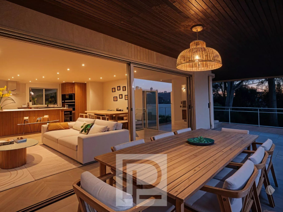 Terrasse d'un appartement rénové à Cannes avec salon et cuisine ouverte.