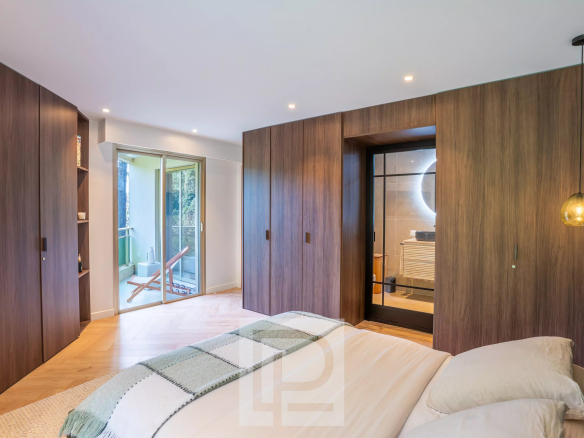 Chambre moderne avec mur en bois, accès à un balcon, et éclairage contemporain.
