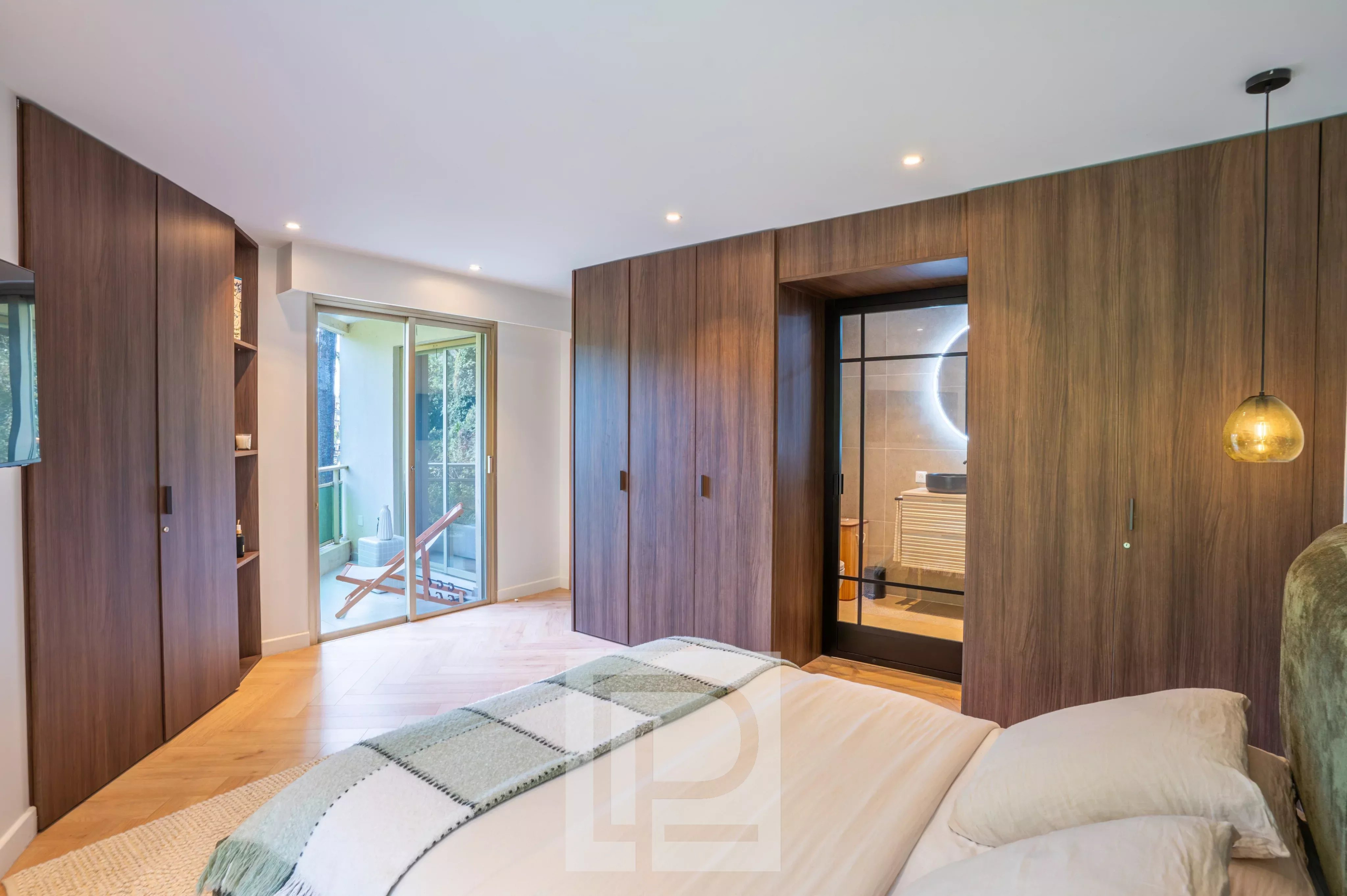 Chambre rénovée avec accès extérieur Chambre moderne avec mur en bois, accès à un balcon, et éclairage contemporain.