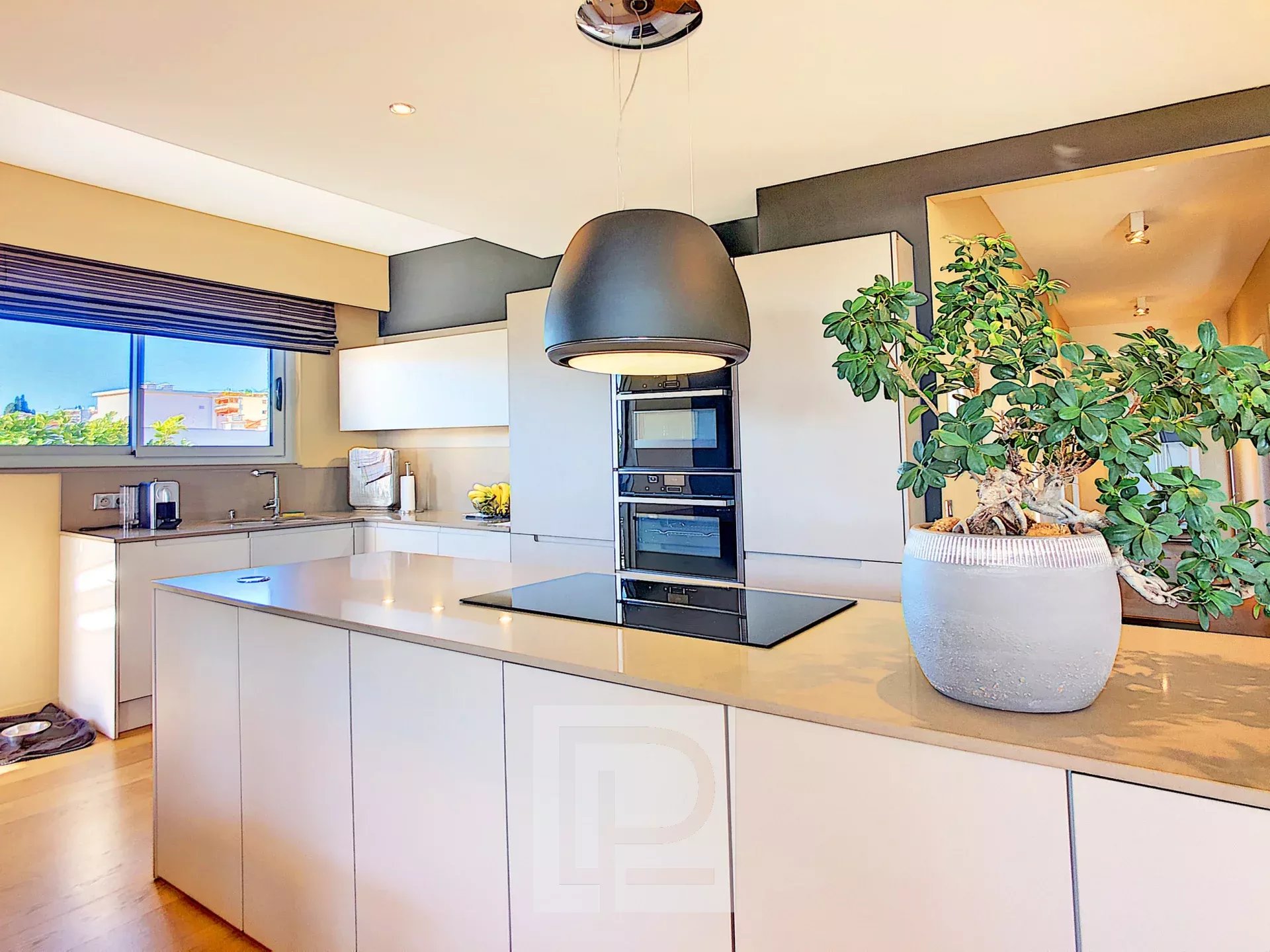 Kitchen of an apartment in Le Cannet Modern and bright kitchen in an apartment with a central island and a view of the outside.