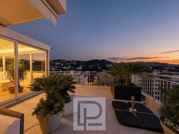Apartment terrace with sunset views in Le Cannet, surrounded by plants.