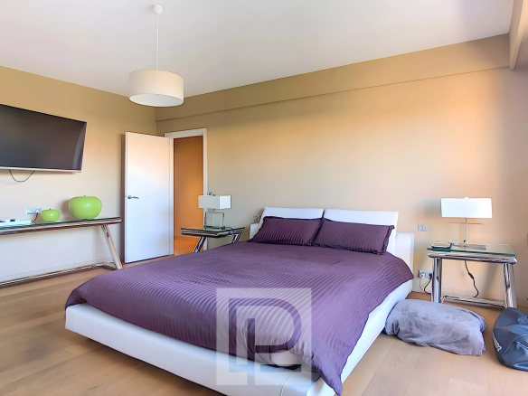 Apartment room with double bed, television and modern decor.