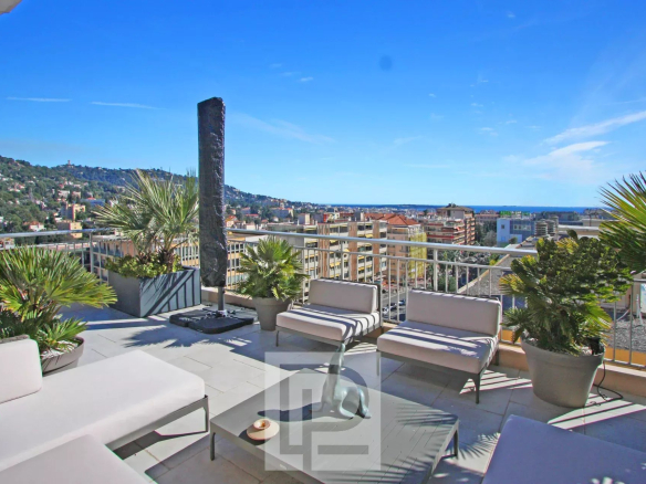 Rooftop of an apartment in Le Cannet with views of the city and the sea, modern furniture and plants.