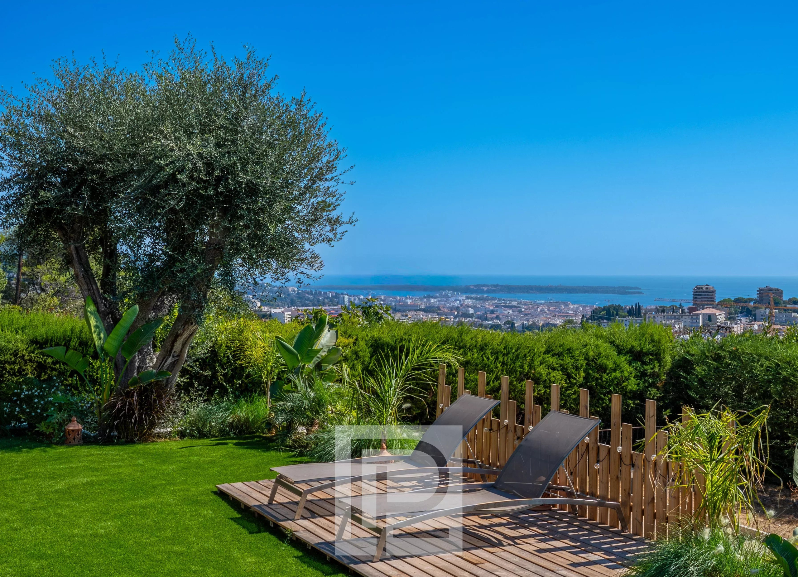 Jardin avec chaises longues et vue panoramique sur la mer à Mougins