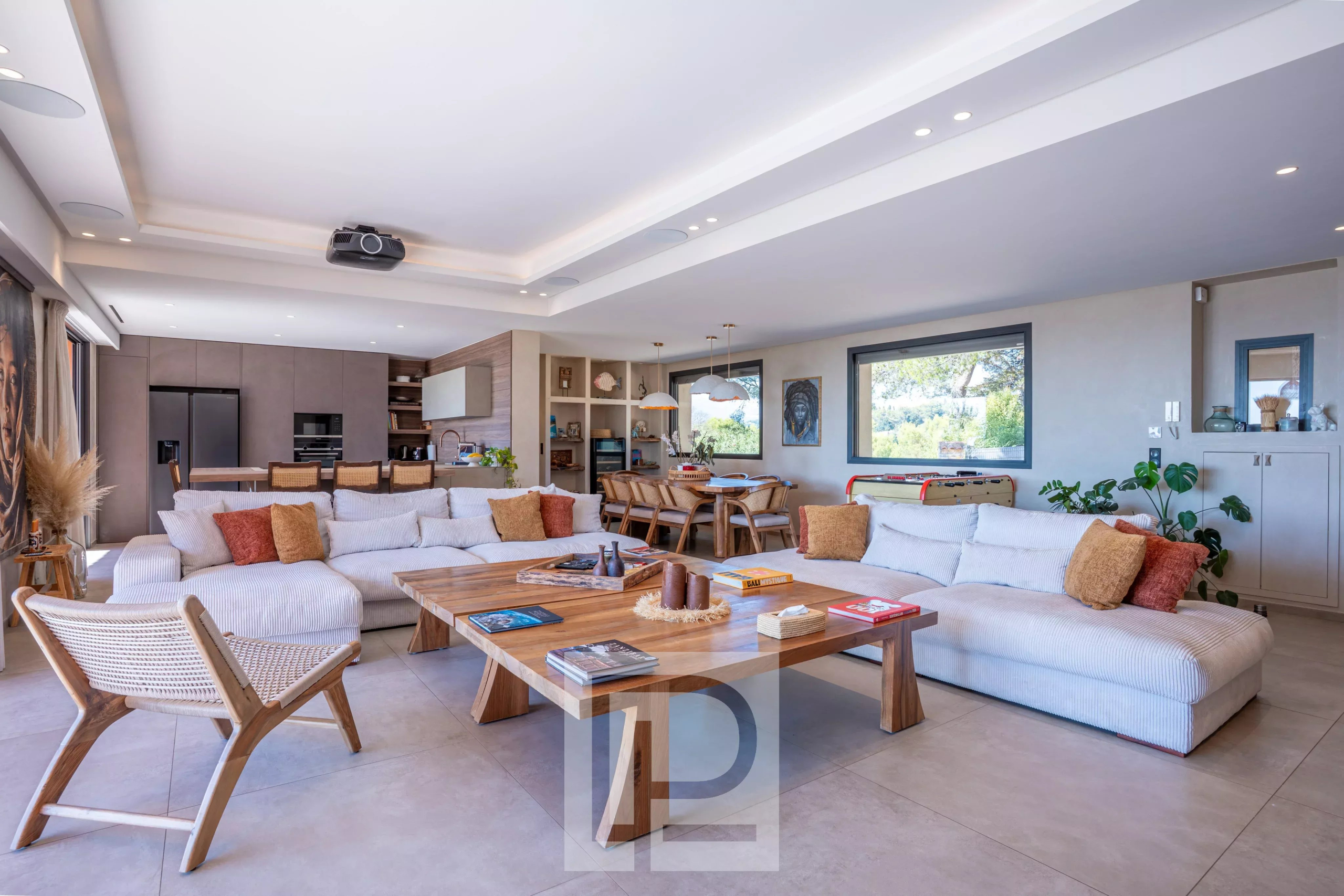 Intérieur d'une villa rénovée avec salon spacieux et cuisine ouverte, vue sur la mer.