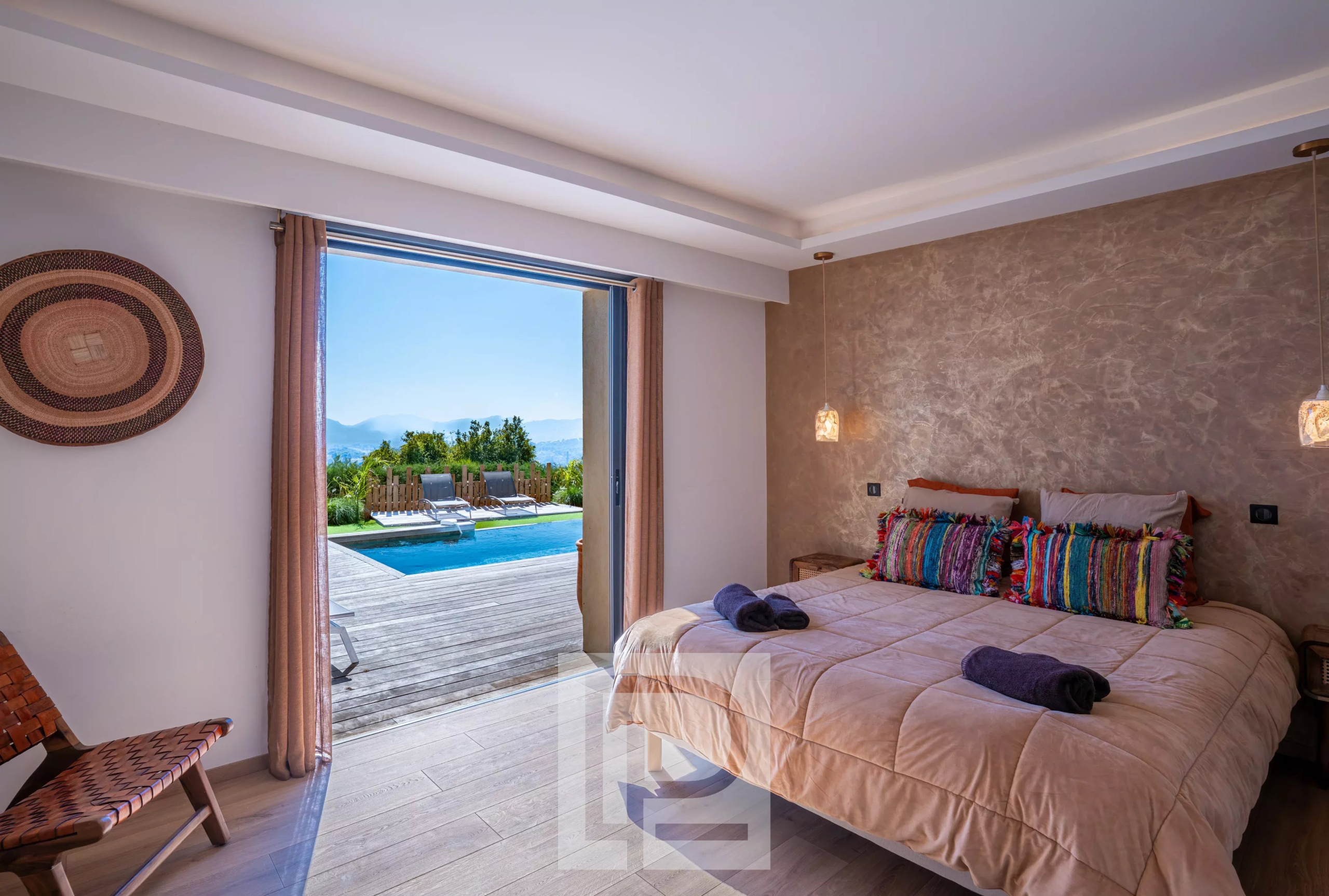 Chambre d'une villa rénovée avec vue sur la mer et accès à la piscine.
