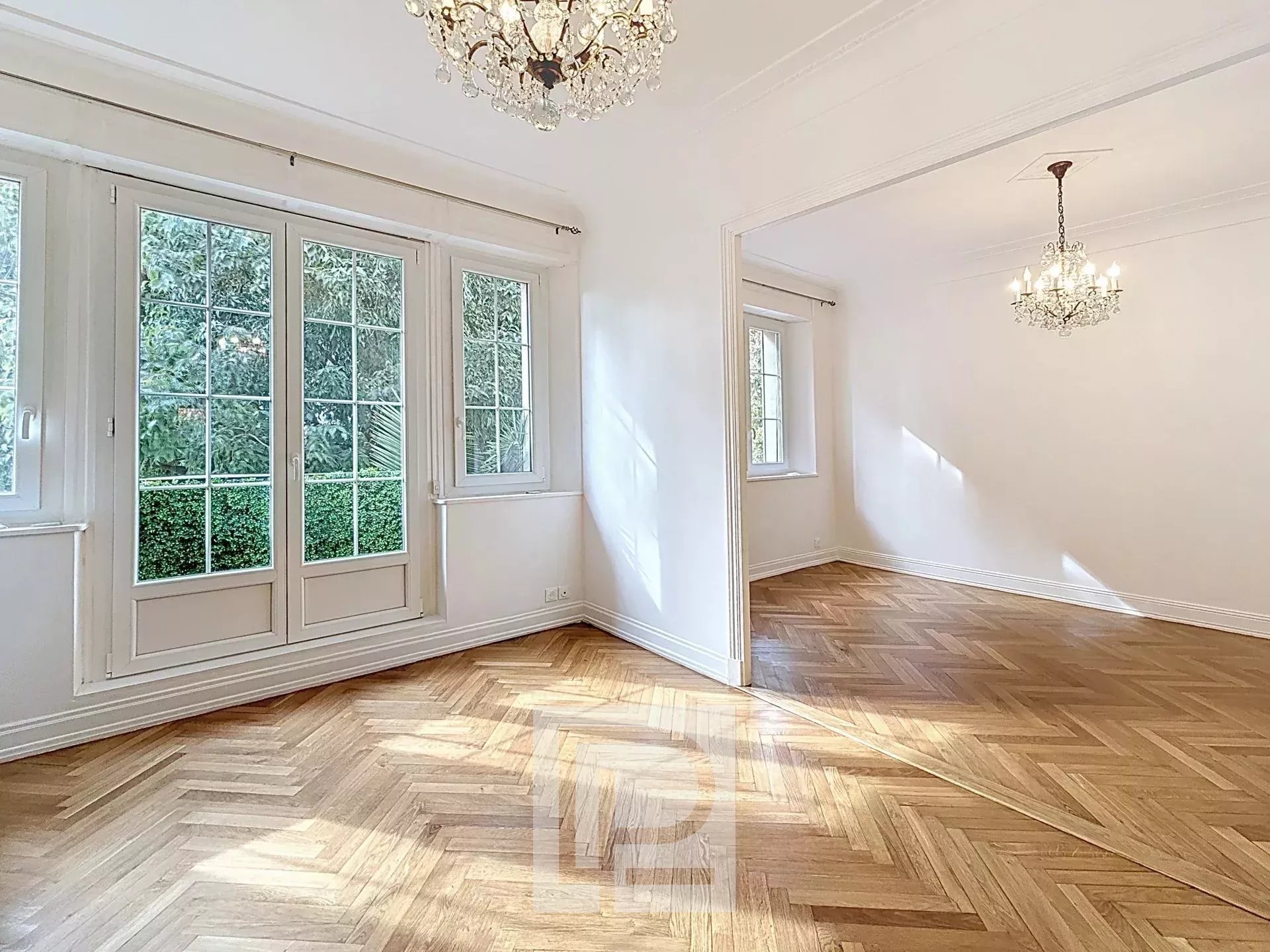 Appartement rénové à Cannes Intérieur d'un appartement rénové avec parquet en bois et grandes fenêtres, lumineux.