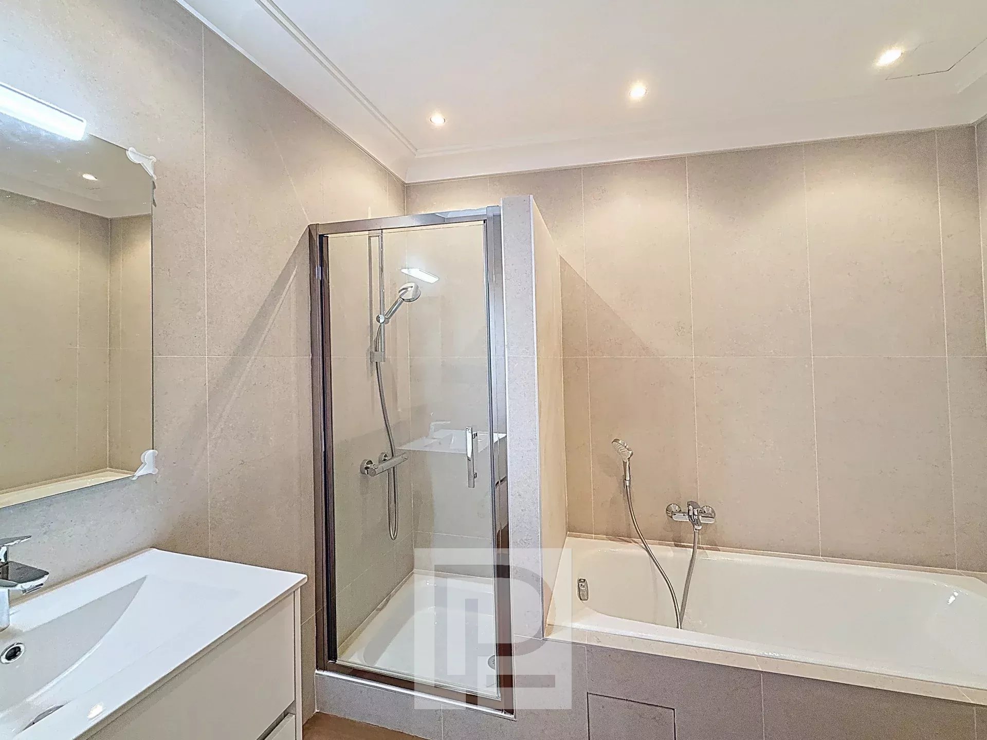 Salle de bain d’un appartement à Cannes Salle de bain moderne avec douche et baignoire dans un appartement rénové à Cannes.