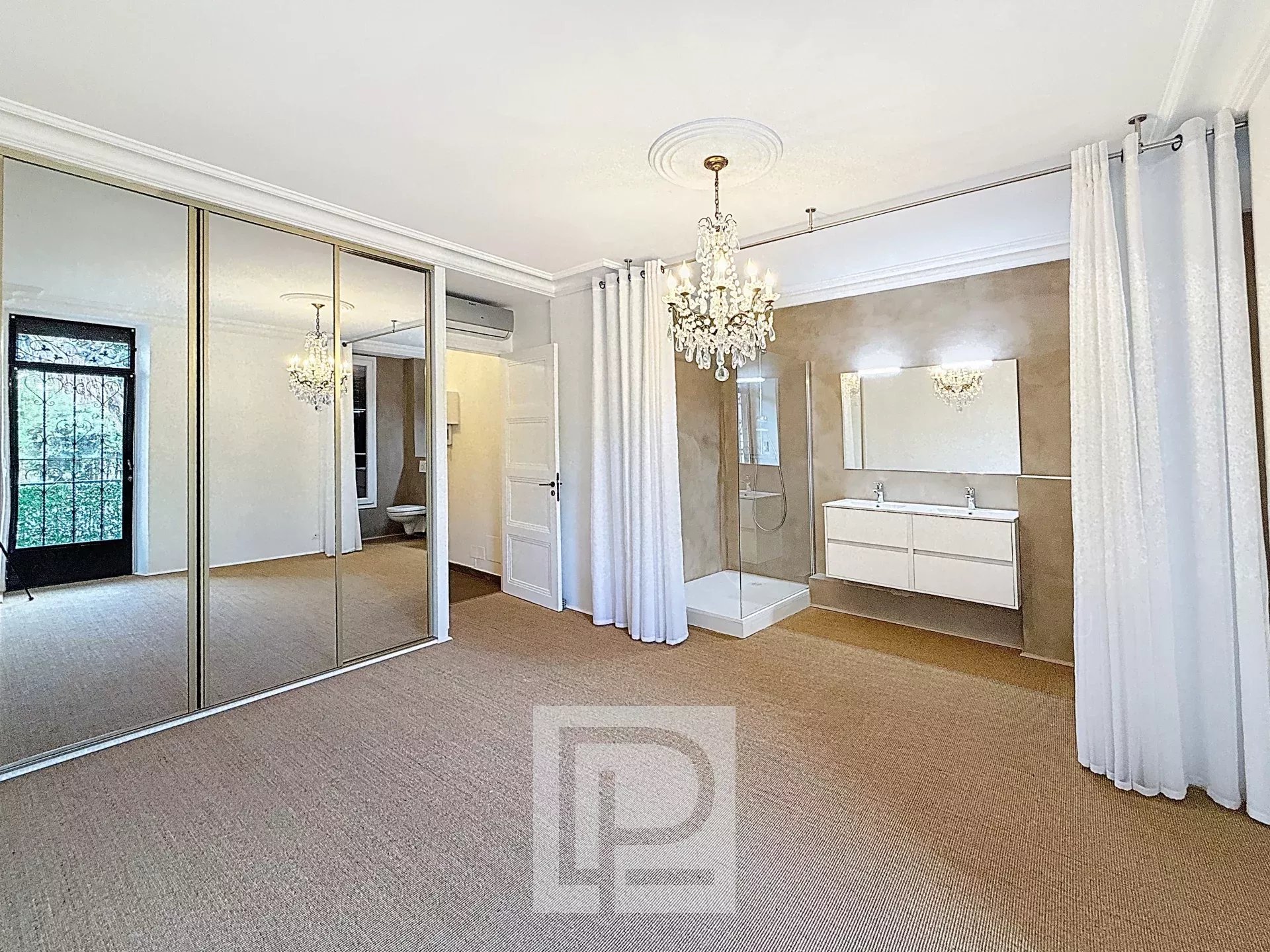Chambre élégante à Cannes Chambre spacieuse avec miroir, lustre et salle de bain dans un appartement à Cannes.