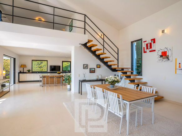 Intérieur d'une villa californienne à Mougins avec salle à manger et escalier moderne.