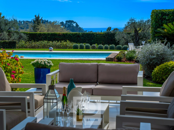 Terrasse d'une villa californienne avec vue sur la mer et un jardin verdoyant à Mougins.