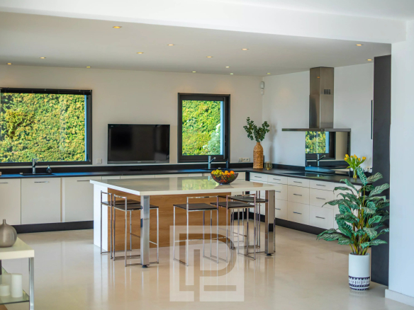 Intérieur d'une villa moderne avec cuisine ouverte et grandes fenêtres à Mougins.