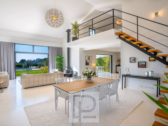 Intérieur d'une villa californienne à Mougins, avec salon lumineux et salle à manger.