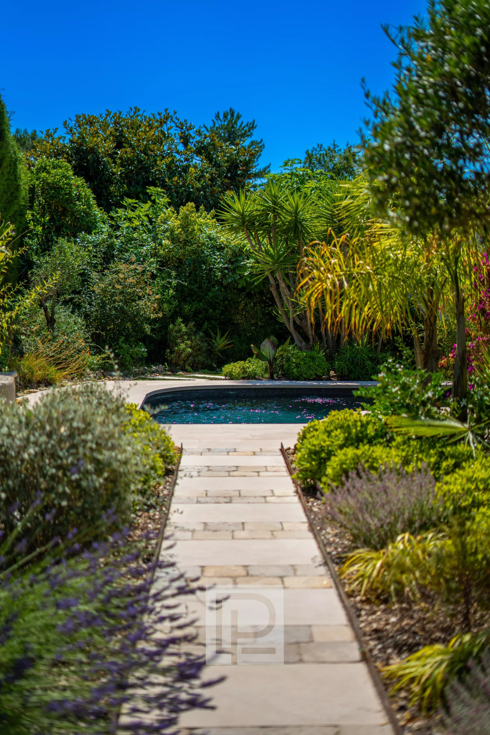 Provençal villa with swimming pool in Mougins Path leading to a swimming pool surrounded by lush vegetation in a villa in Mougins.