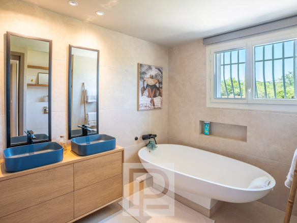 Modern bathroom with bathtub, double sink and mirror, in a Provençal villa in Mougins.