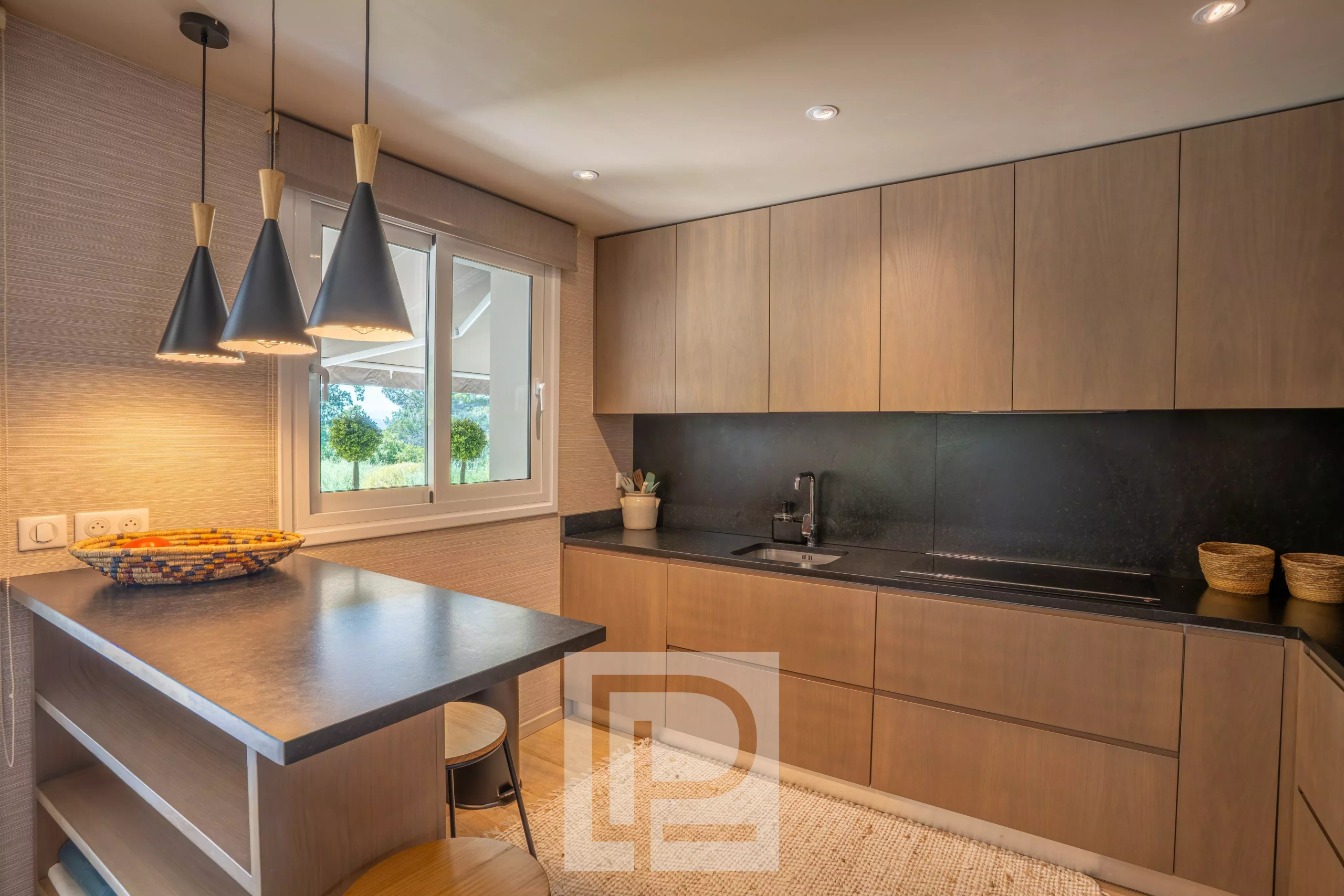 Kitchen of a Provençal villa in Mougins Modern kitchen with a bar and elegant lighting in a Provençal villa in Mougins.