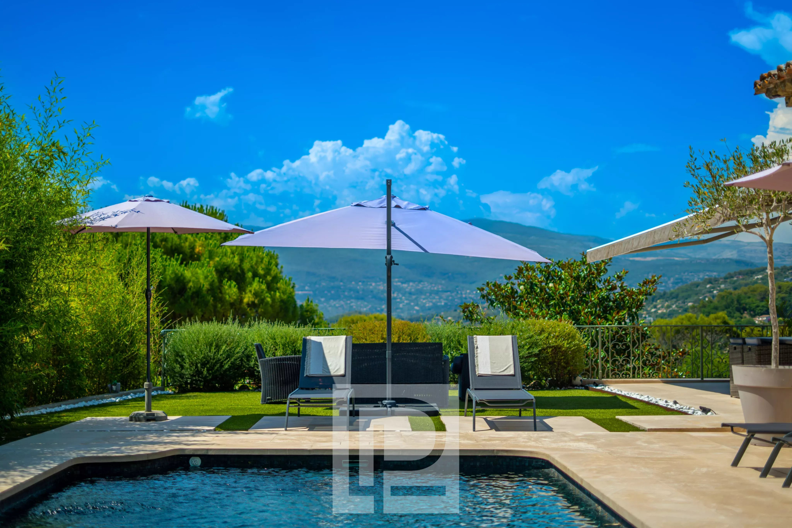 Provençal villa with swimming pool in Mougins View of a Provençal villa with swimming pool, parasols and green landscape in Mougins.