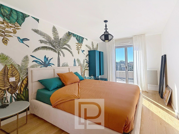 Chambre d'appartement avec décoration végétale, lit double et vue sur les collines.