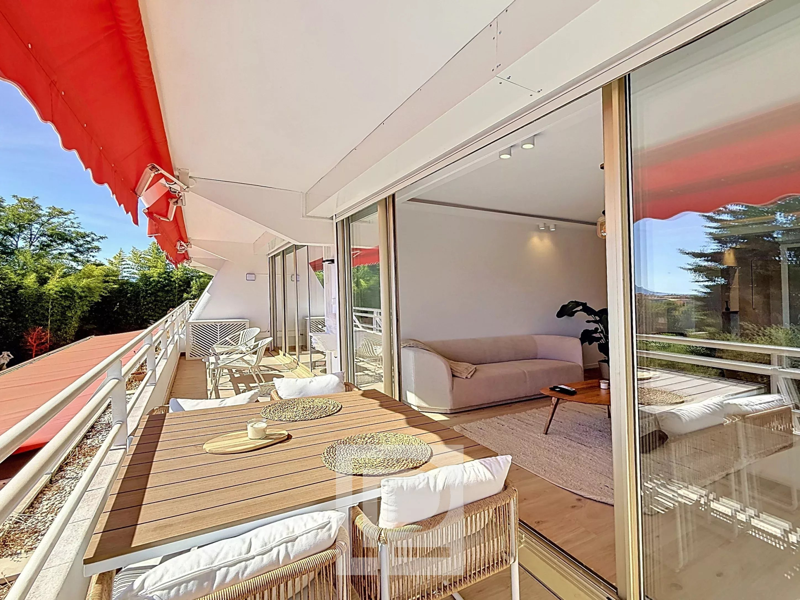 Terrasse d’un appartement rénové à Cannes Terrasse d'un appartement rénové à Cannes, avec mobilier et vue sur la verdure.