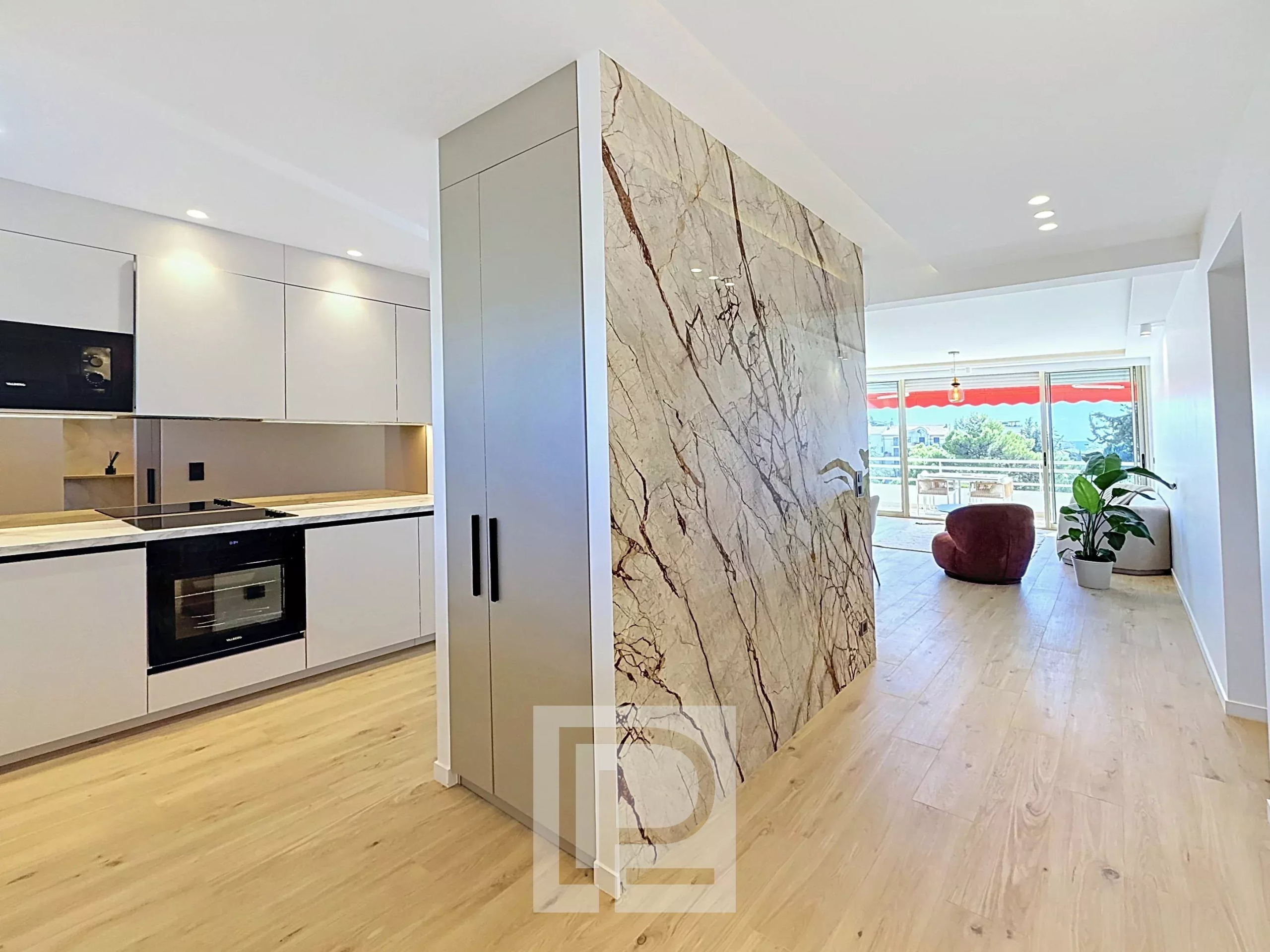 Appartement rénové à Cannes Intérieur d'un appartement rénové à Cannes, avec cuisine moderne et mur en marbre.
