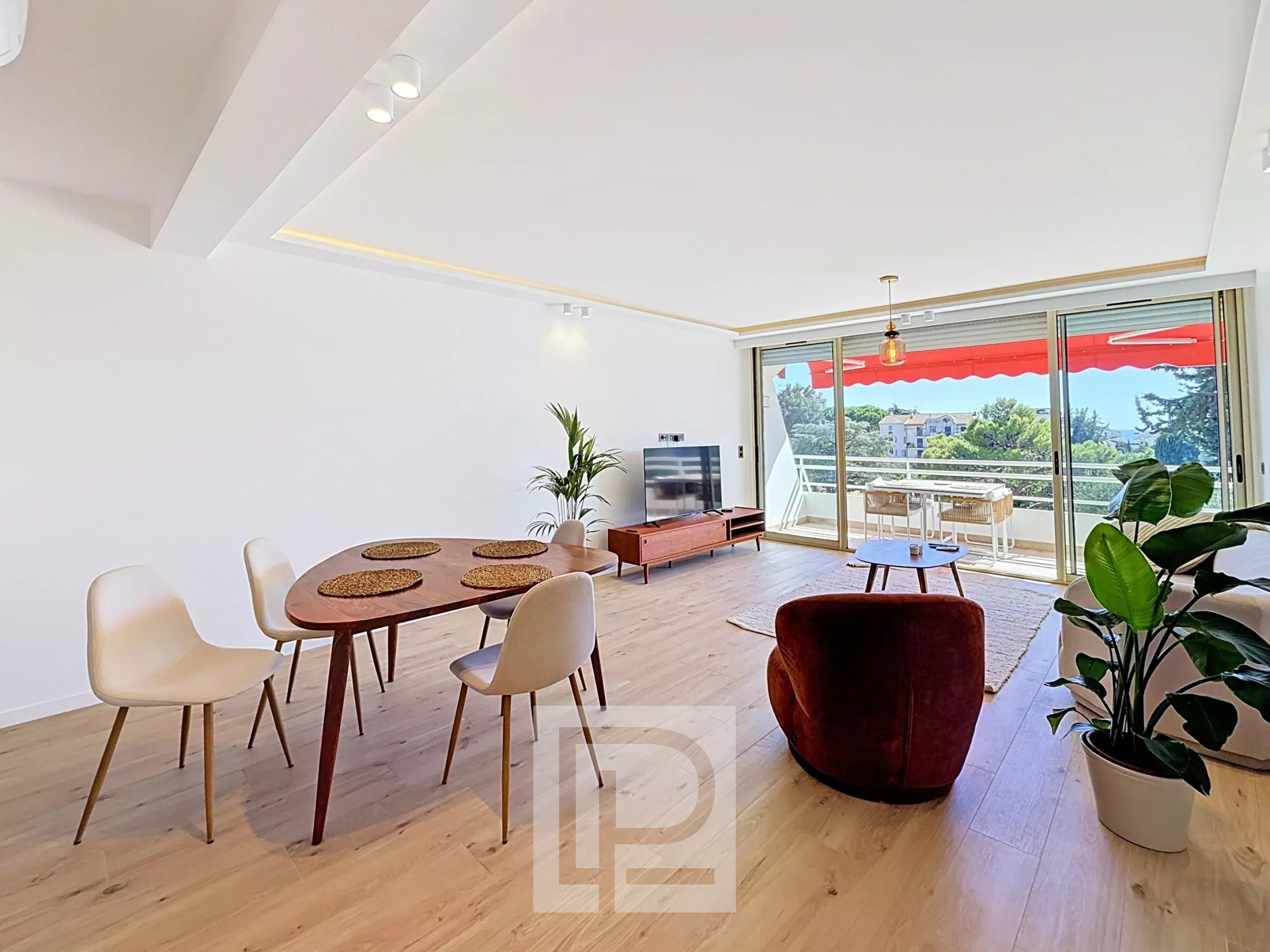 Appartement rénové à Cannes Intérieur d'un appartement rénové à Cannes avec salon, table à manger et balcon.