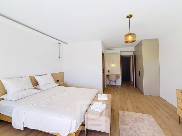 Chambre d'un appartement rénové à Cannes, avec lit double et décoration moderne.