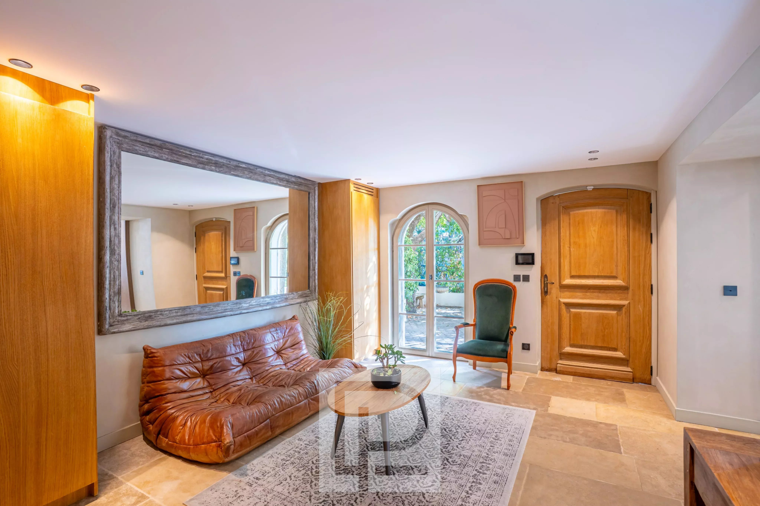 Intérieur d’une bastide rénovée Intérieur d'une bastide rénovée avec un salon lumineux, un miroir et une porte en bois.