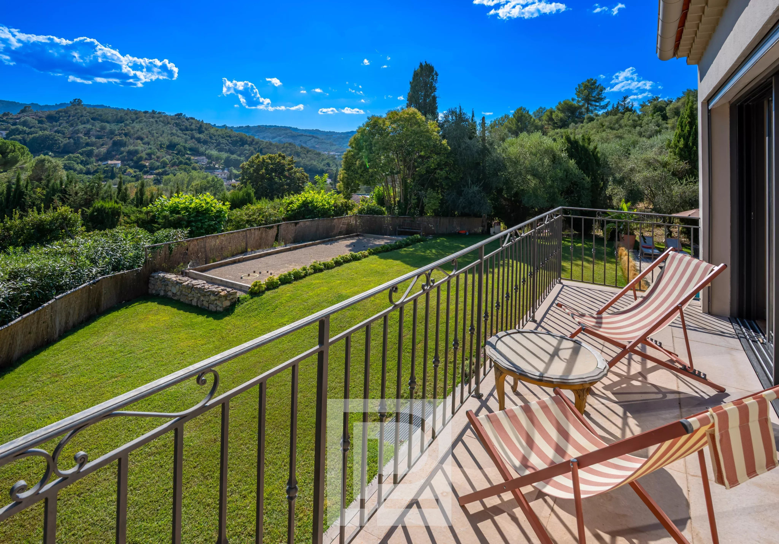 Bastide rénovée avec vue Terrasse d'une bastide rénovée avec vue sur des collines verdoyantes et un jardin.