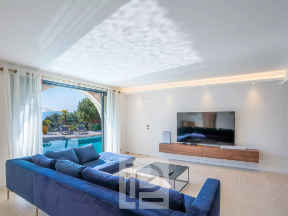 Intérieur d'une villa à Mougins avec un salon moderne et vue sur la piscine.