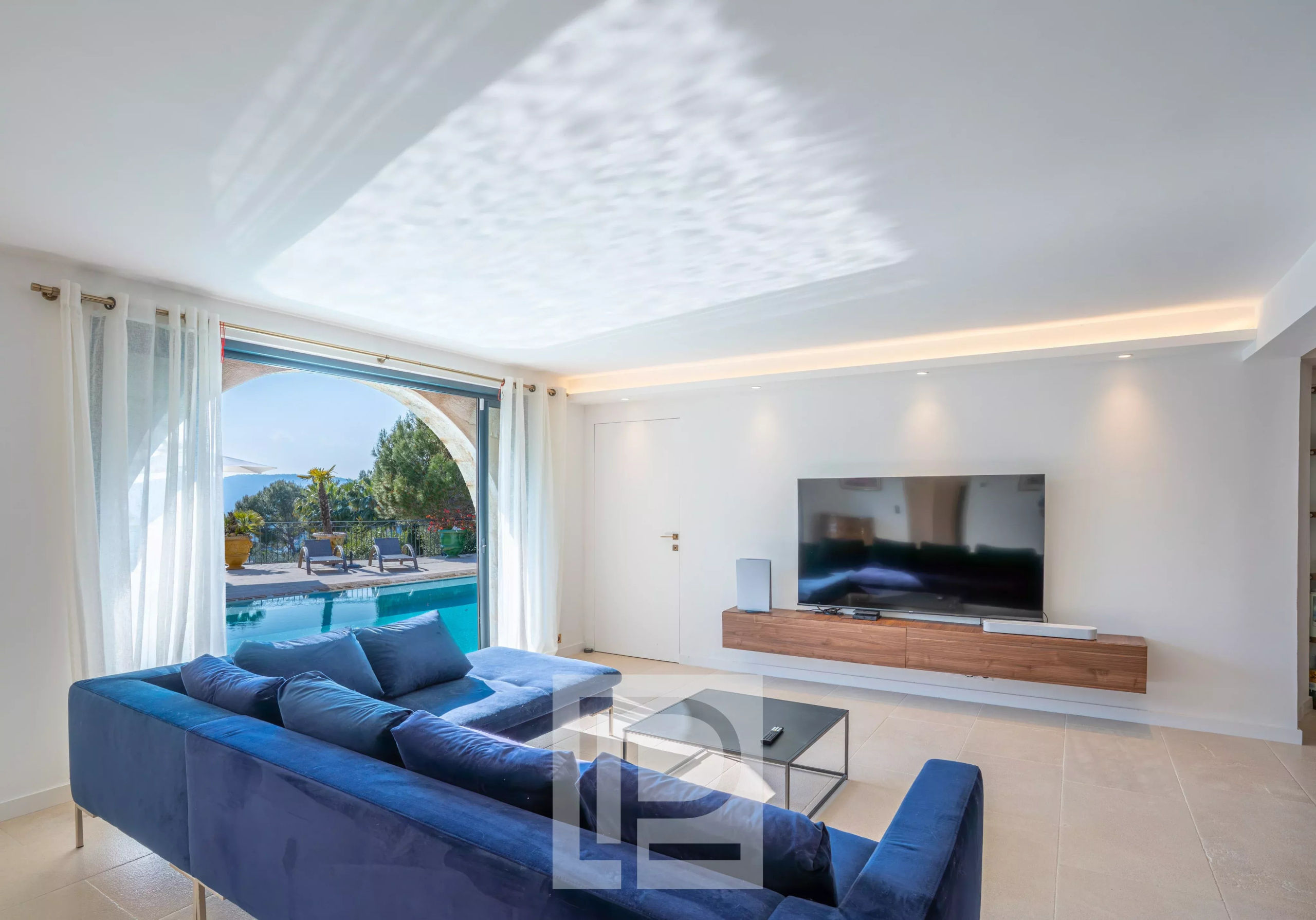 Intérieur d'une villa à Mougins avec un salon moderne et vue sur la piscine.