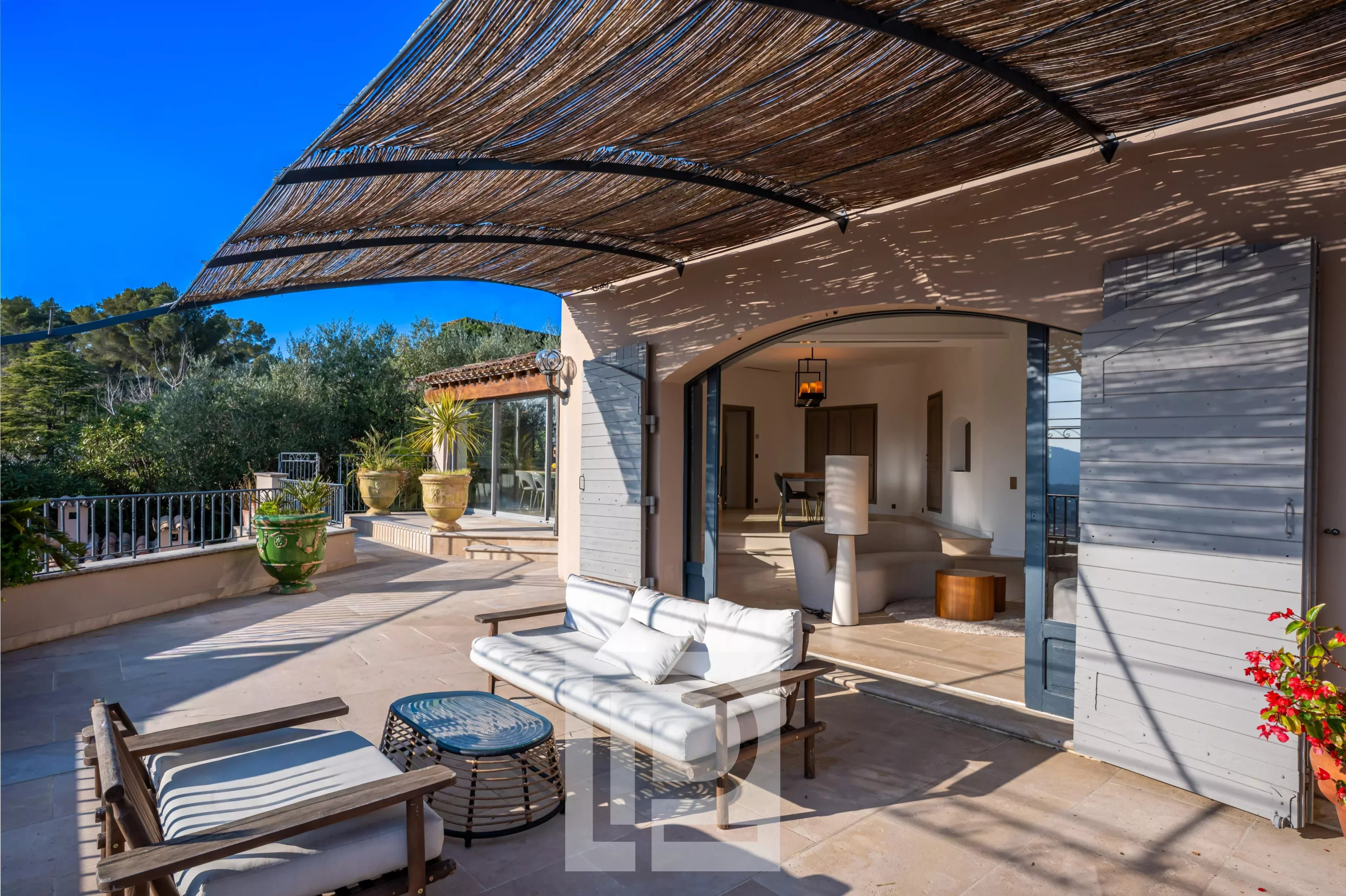 Terrasse d'une villa à Mougins avec mobilier extérieur et vue dégagée.