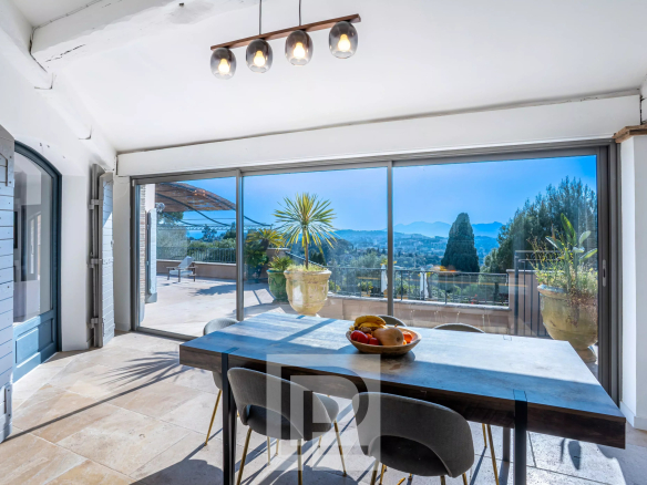 Vue intérieure d'une villa à Mougins avec une grande baie vitrée et une table à manger.