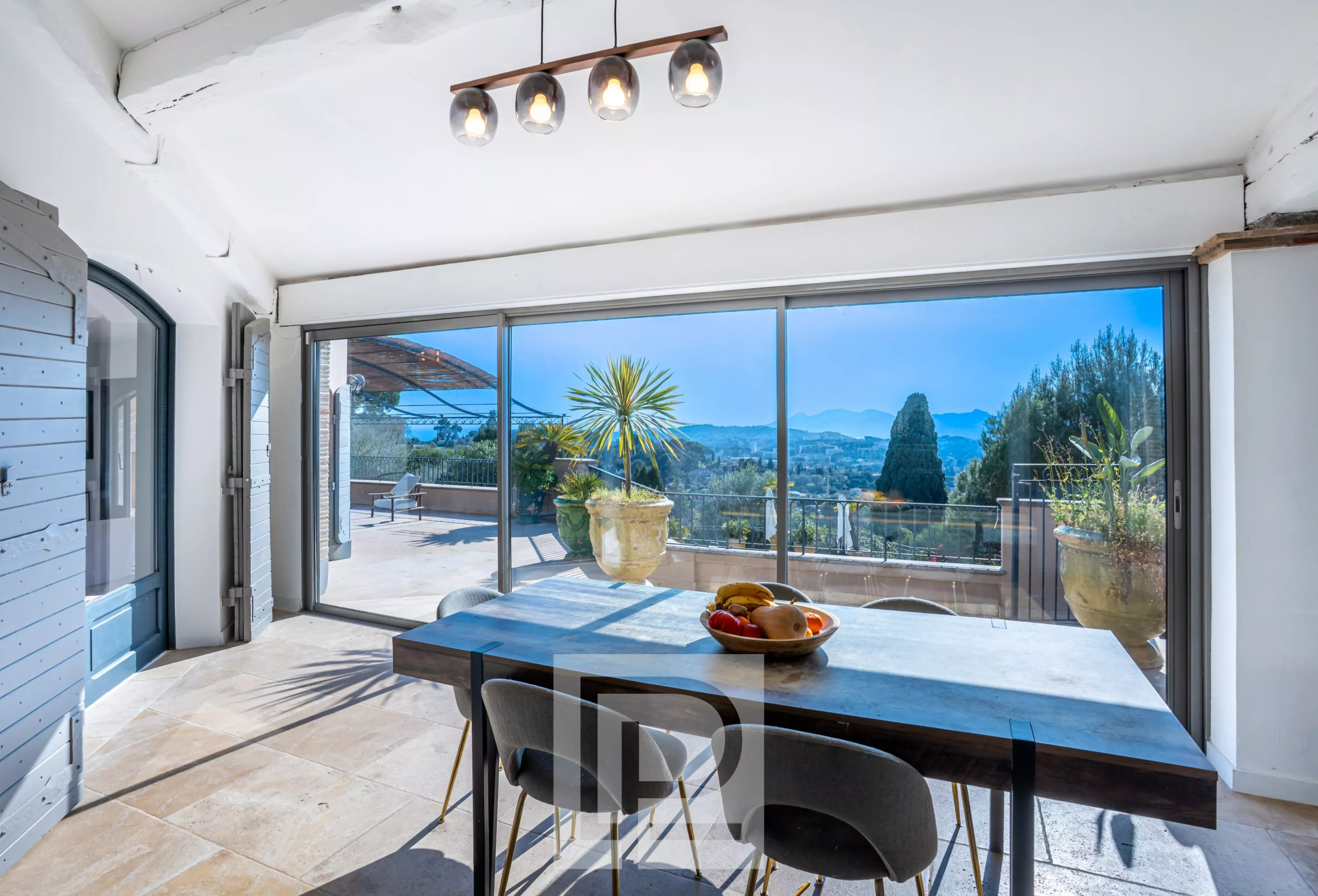 Vue intérieure d'une villa à Mougins avec une grande baie vitrée et une table à manger.