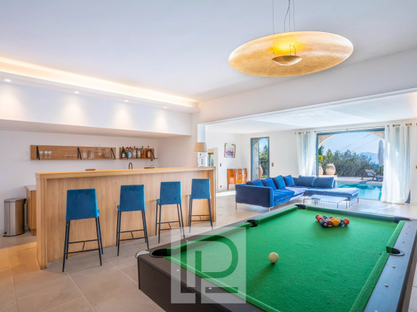 Intérieur d'une villa à Mougins avec billard, bar et salon lumineux.