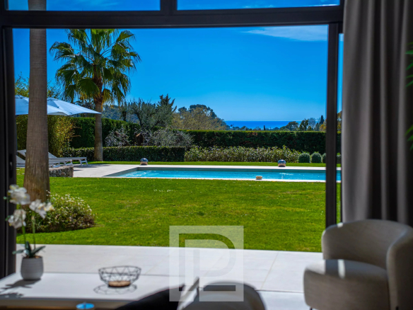 View from inside a Californian villa with swimming pool and sea in the background in Mougins.