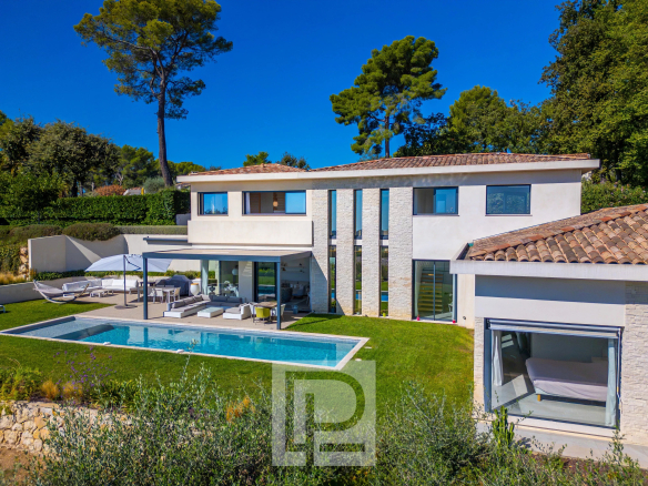 Villa contemporaine avec piscine à Roquefort-les-Pins, vue panoramique sur la nature.