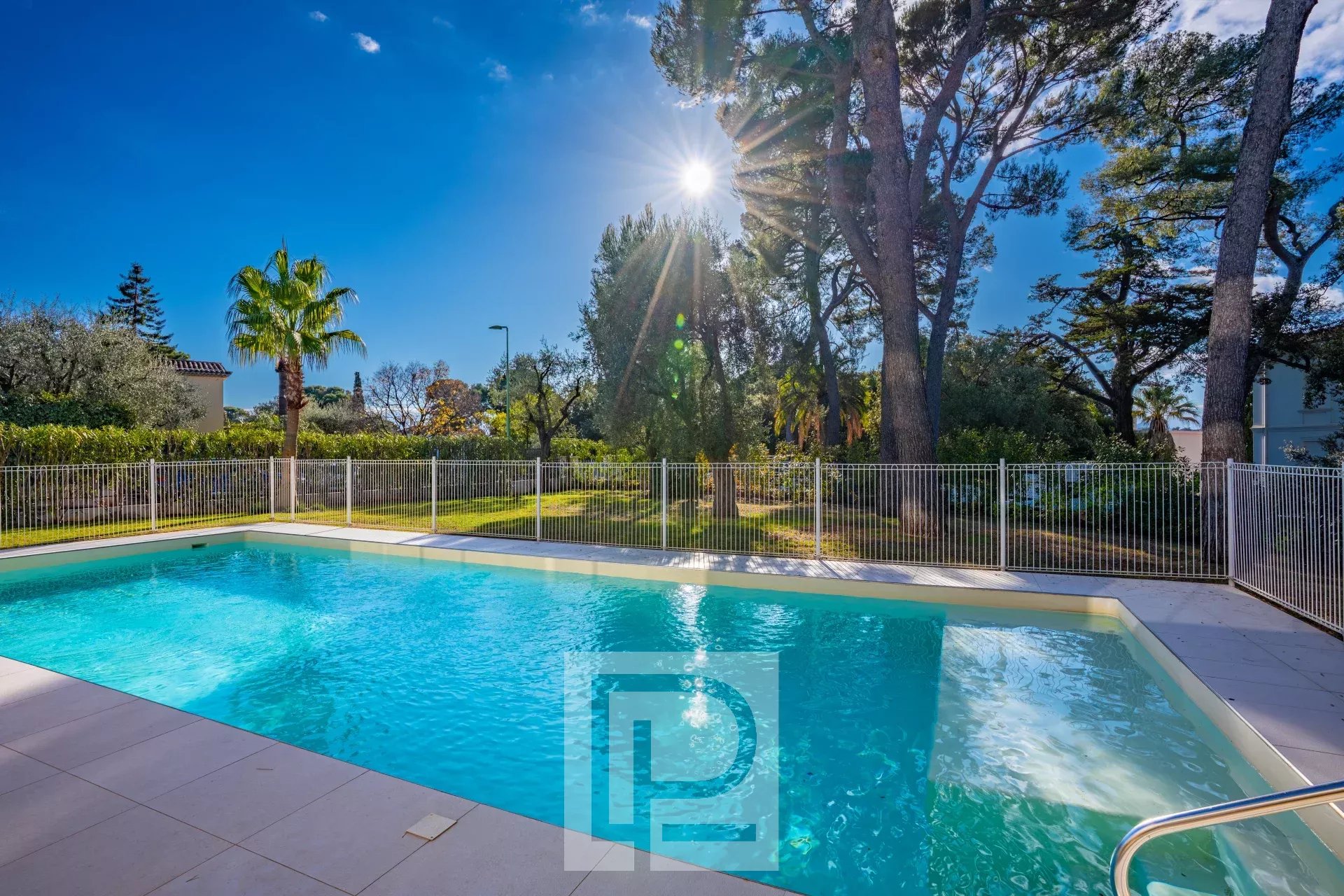 Piscine de la résidence au Cannet Piscine d'une résidence avec vue sur le soleil et des arbres au Cannet.