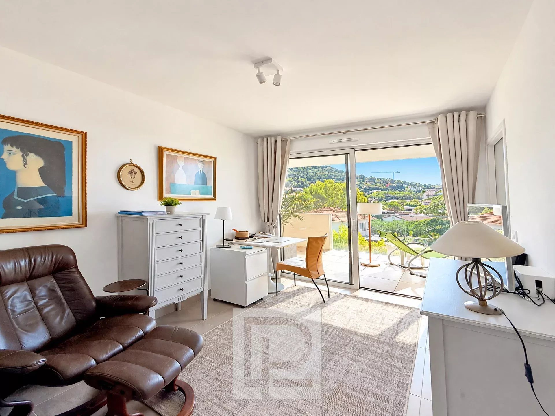 Appartement avec vue panoramique au Cannet Salon lumineux d'un appartement avec vue sur les collines et la mer, mobilier moderne et accès à un balcon.