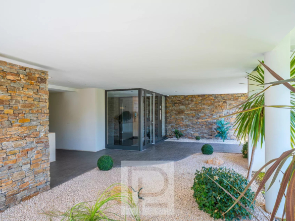 Entrée d'un appartement moderne avec des murs en pierre et un jardin paysager