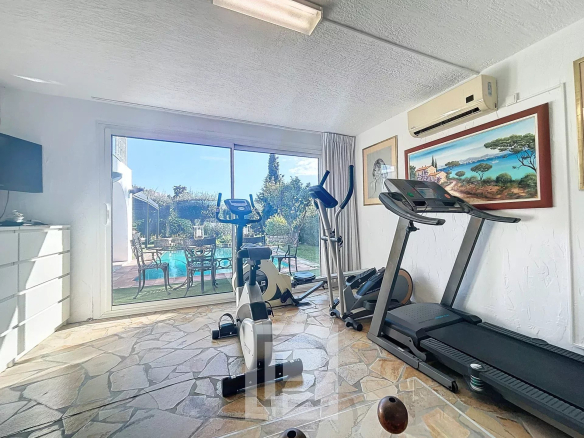 Salle de sport avec équipements de fitness et vue sur la piscine à Cannes, Basse Californie.