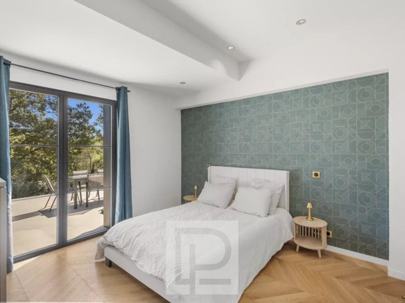 Chambre d'une villa rénovée avec vue dégagée à Valbonne, murs clairs et décoration moderne.