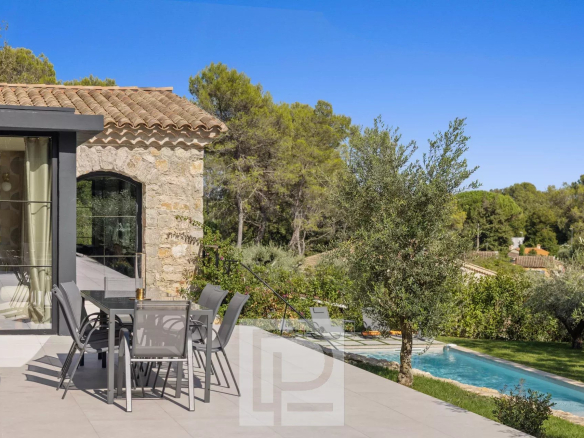 Terrasse d'une villa en pierre rénovée avec piscine à Valbonne, vue dégagée sur la nature.