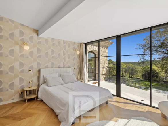 Chambre d'une villa en pierre rénovée à Valbonne avec vue sur la nature.