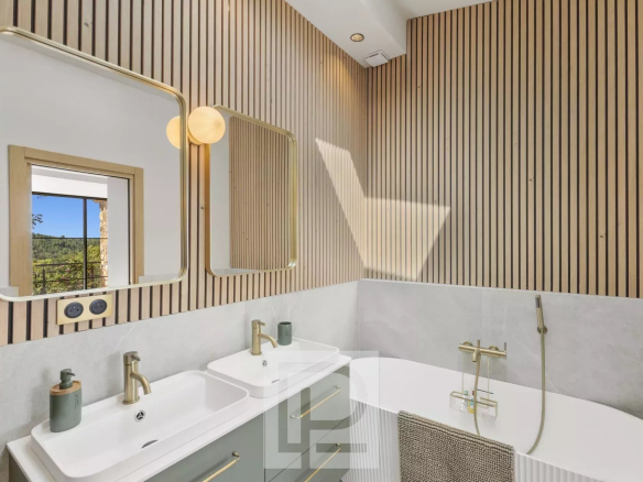 Salle de bain moderne avec baignoire et double vasque, murs en bois et carrelage clair