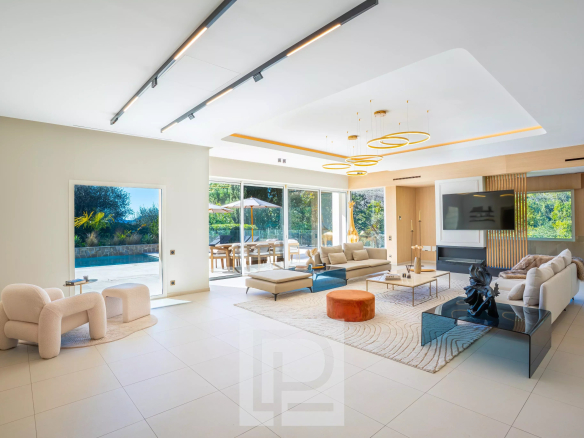 Intérieur d'une villa contemporaine avec un grand salon lumineux et un accès à l'extérieur.