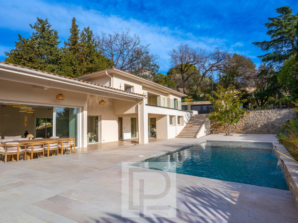 Villa contemporaine avec piscine et terrasse à Mougins, entourée de verdure.