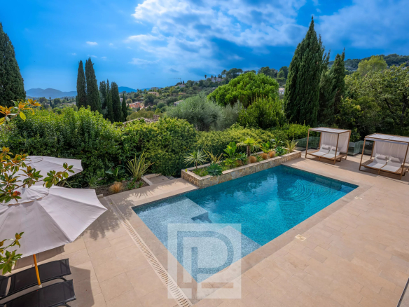 Piscine et espace extérieur d'une villa contemporaine à Mougins, avec des chaises longues et des parasols.