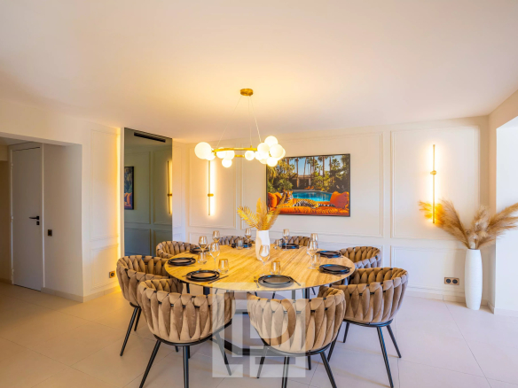 Salle à manger d'une villa contemporaine avec une grande table ronde et des chaises élégantes.